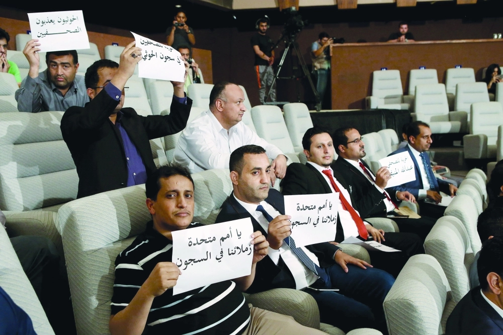 صحفيون يرفعون لافتات للإفراج عن زملائهم بسجون الحوثيين خلال مؤتمر صحفي لولد الشيخ بالكويت                 (أ ف ب)