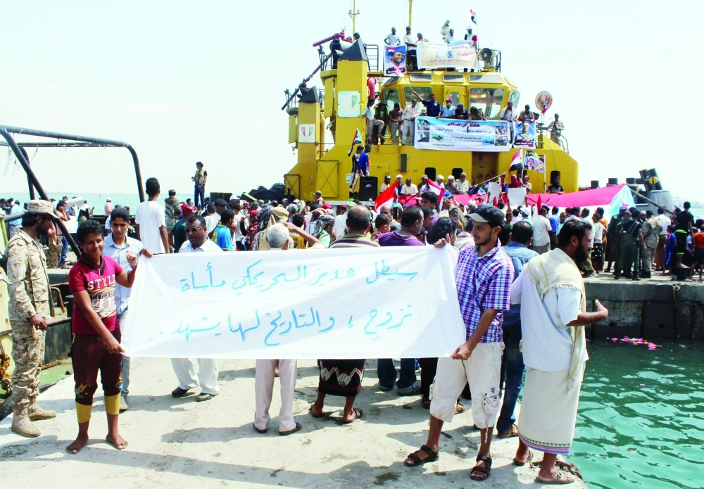 تجمع يمني بميناء التواهي بعدن في ذكرى مرور عام على قصف الحوثيين للمدنيين الذين حاولوا الفرار بالزوارق                               (أ ف ب)