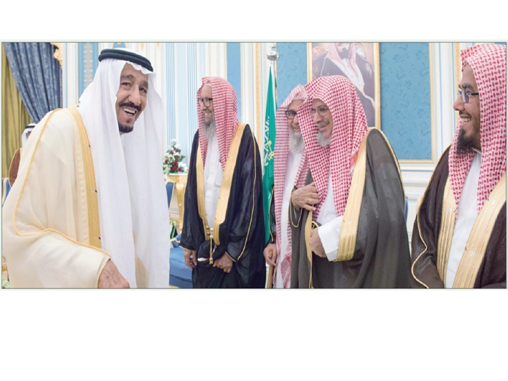 
خادم الحرمين في حوار باسم مع علماء خلال الاستقبال أمس (واس)