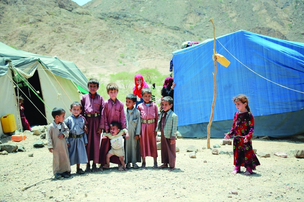 أطفال يمنيون خارج الخيام في معسكر موقت للفارين من قصف الحوثي في نهم غرب مأرب     (أ ف ب)