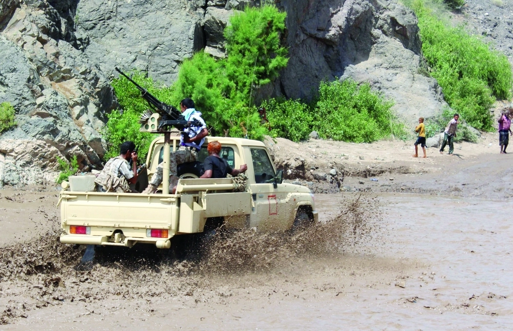 سيارة عسكرية تعبر مجرى مائيا خلال اشتباكات مع الانقلابيين في كرش بلحج                     (أ ف ب)