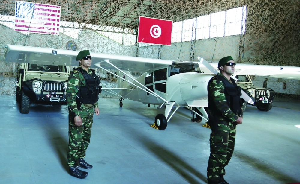 عنصران من القوات التونسية بجانب معدات عسكرية مقدمة من واشنطن                                   (رويترز)