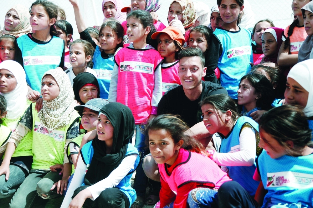 اللاعب الألماني مسعود أوزيل مع لاجئين سوريين في الزعتري                                    (أ ف ب)