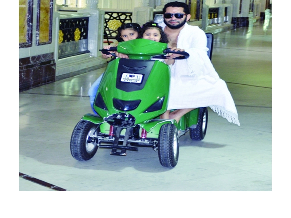 معتمر يقود عربة في المسعى برفقة أطفاله  (عبدالمحسن دومان)