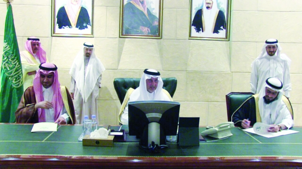 خالد الفيصل متوسطا هشام الفالح ومحمد الحارثي خلال توقيع الشراكة بين التعليم والسقاية                  (مكة)