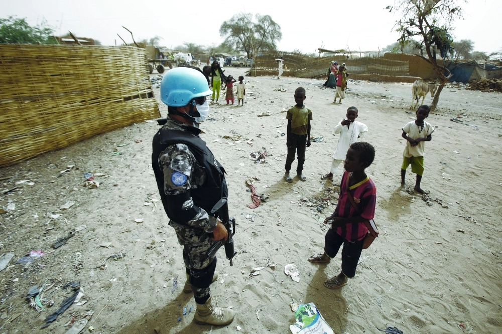 جندي في بعثة اليوناميد بجوار أطفال في دارفور                                               (أ ف ب)