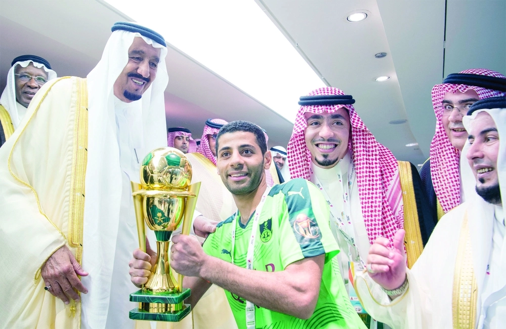 خادم الحرمين الشريفين متوجا قائد الأهلي بكأس الملك أمس في جدة (بندر الجلعود)