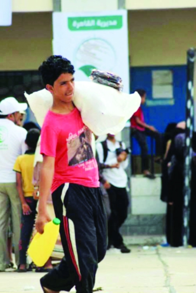 شاب يمني يحمل مساعدات غذائية سعودية             (واس)