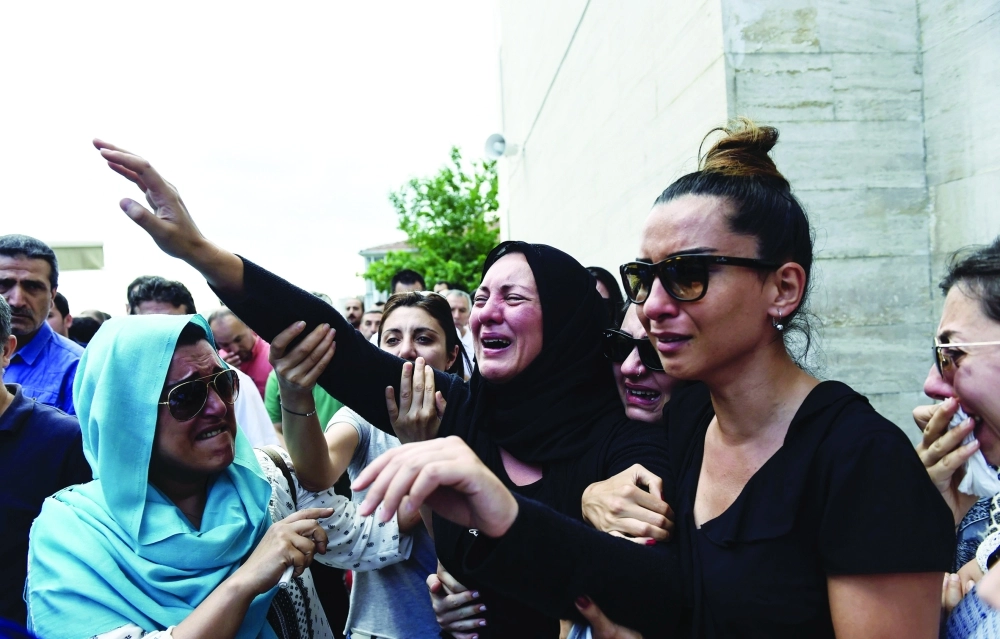 عوائل منهارة وهي تودع جنازة أحد أفرادها                          (أ ف ب)