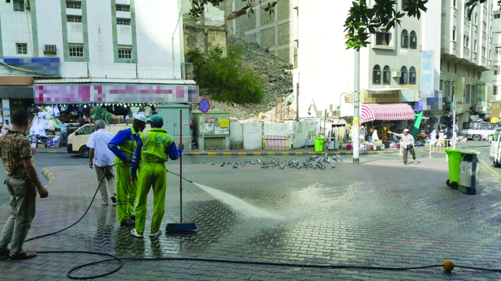 عمال يغسلون الشوارع ‫في العاصمة المقدسة              (مكة)