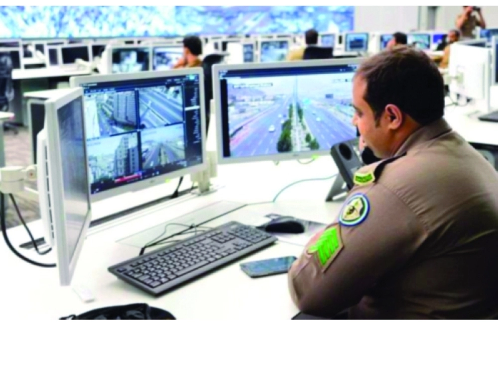 أحد أفراد مركز 911 يراقب لقطات الكاميرات ذات التقنيات العالية (مكة) 