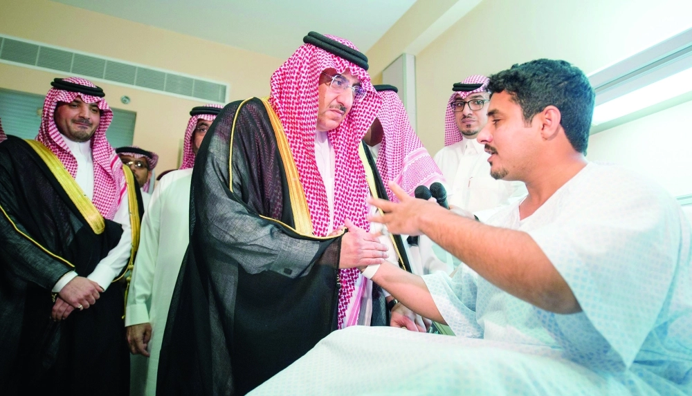 الأمير محمد بن نايف لدى زيارته أحد المصابين في المستشفى (واس) 
