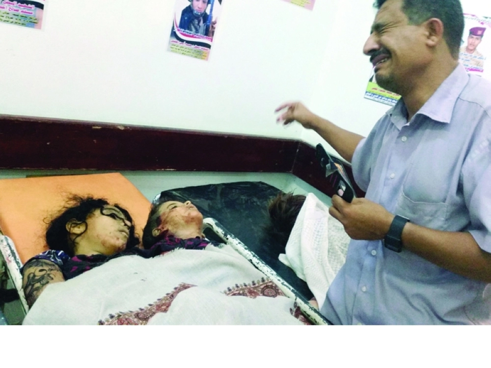 يمني يبكي بجوار جثامين أطفاله الذين قتلوا بقصف حوثي في مأرب أول أيام العيد (أ ف ب)