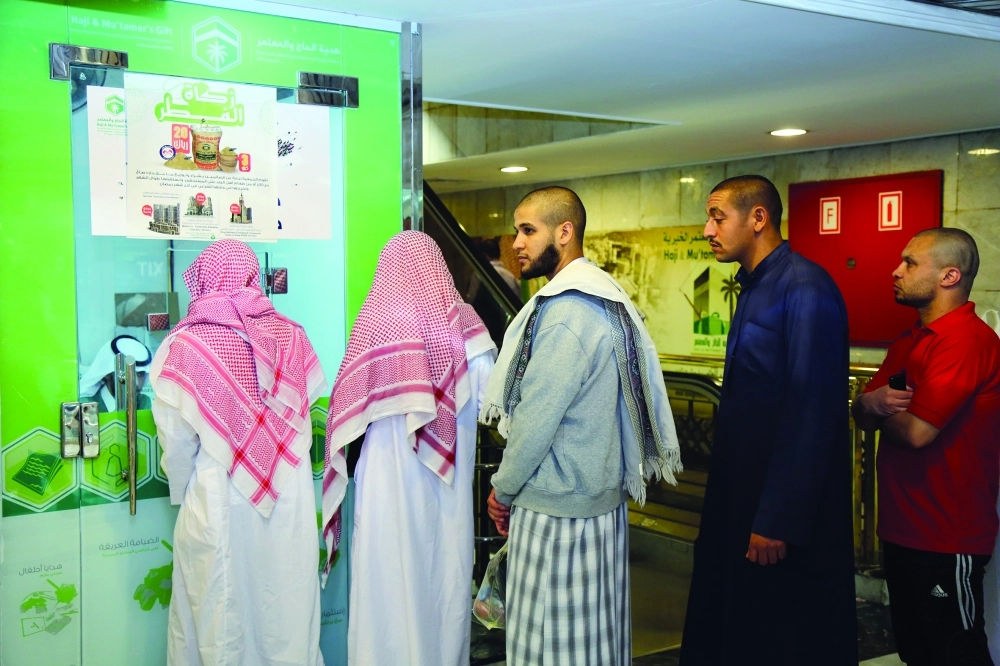 معتمرون وزوار خلال إخراجهم الزكاة                                                                     (أحمد جابر) 