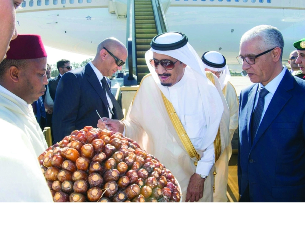 الملك سلمان متناولا التمر لدى وصوله