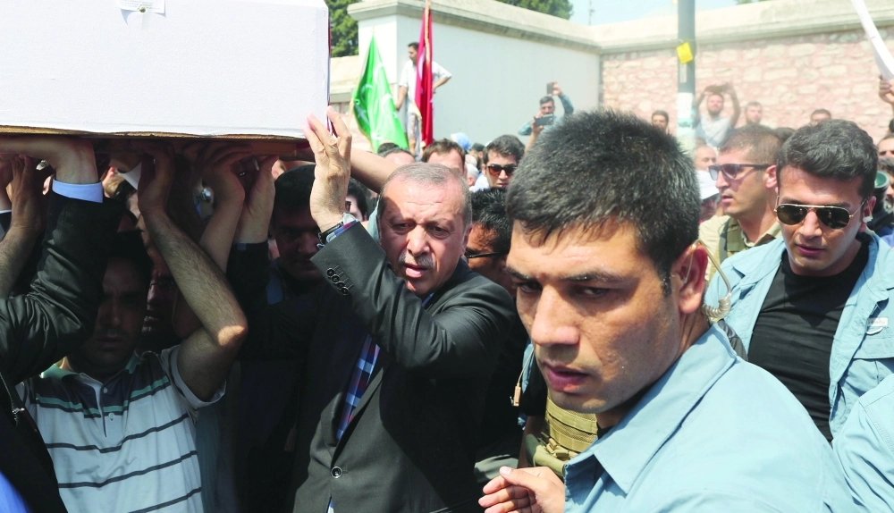 إردوغان يحمل نعشا خلال تشييع ضحايا محاولة الانقلاب بإسطنبول أمس       (إ ب أ)