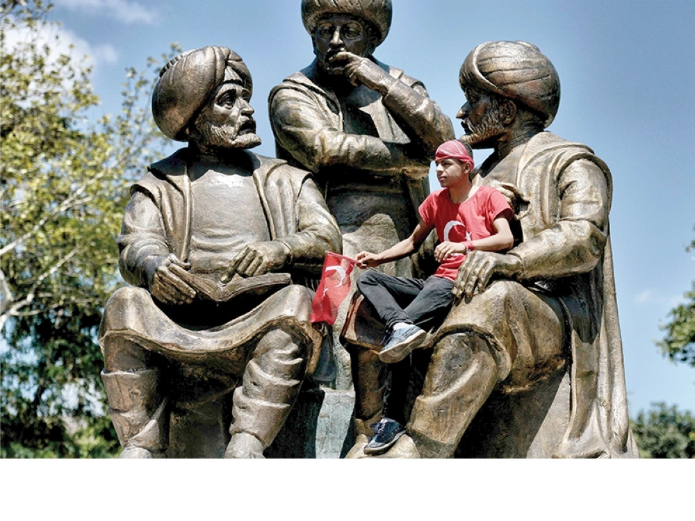 مؤيد لإردوغان في حضن تمثال السلطان محمد الفاتح (أ ف ب)