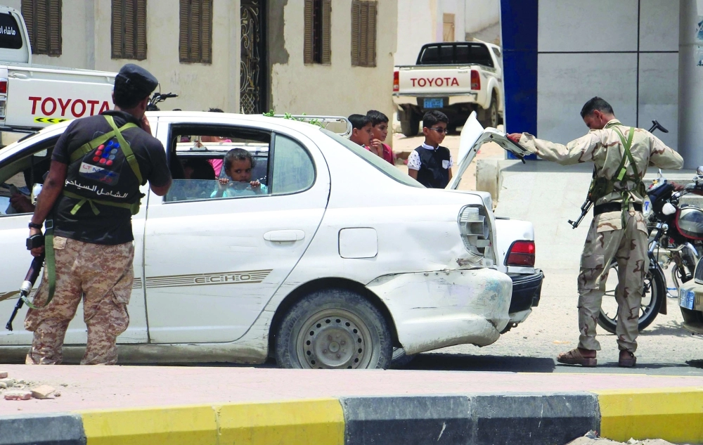 جنود يفتشون سيارات في نقطة تفتيش بالمكلا                                 (أ ف ب)