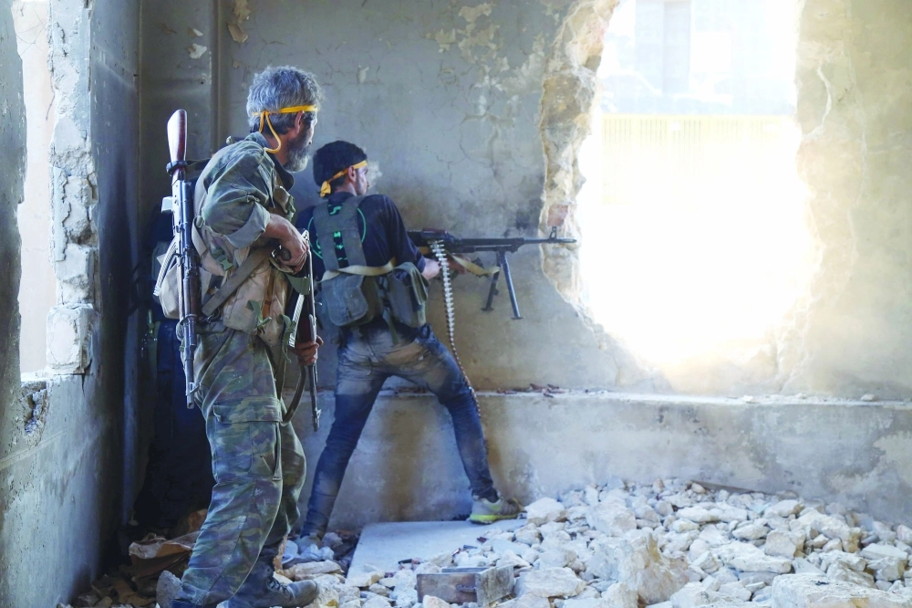 مقاتلون خلال اشتباكات مع النظام في حي الراموسة بحلب أمس           (أ ف ب)