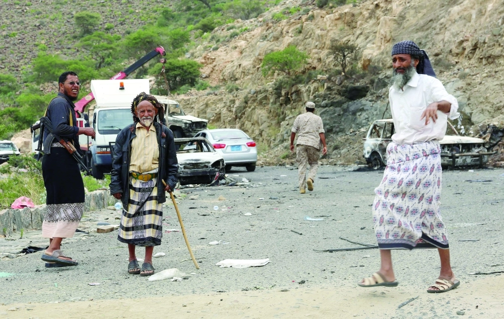 مسن يسير بجوار عناصر من المقاومة الشعبية بمنطقة يافا شمال عدن أمس                                                                                      (أ ف ب)