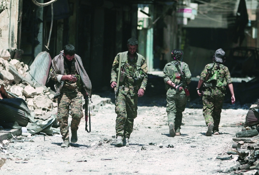 عناصر من قوات سوريا الديمقراطية يتفقدون المواقع في منبج            (رويترز)