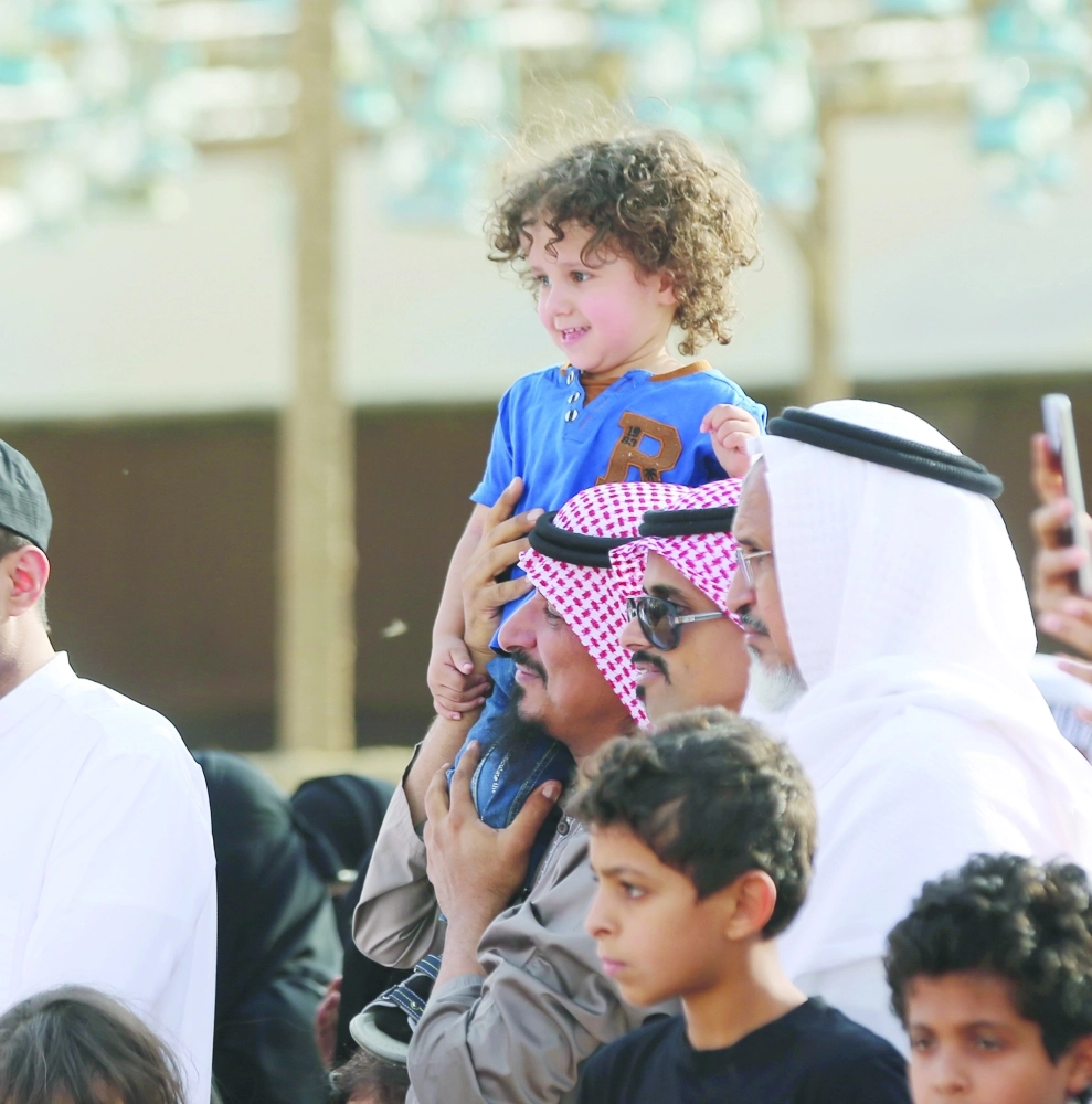 طفل يشاهد العروض من على كتف والده