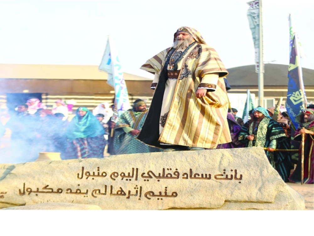 شاعر يقف منشدا على إحدى صخرات عكاظ 