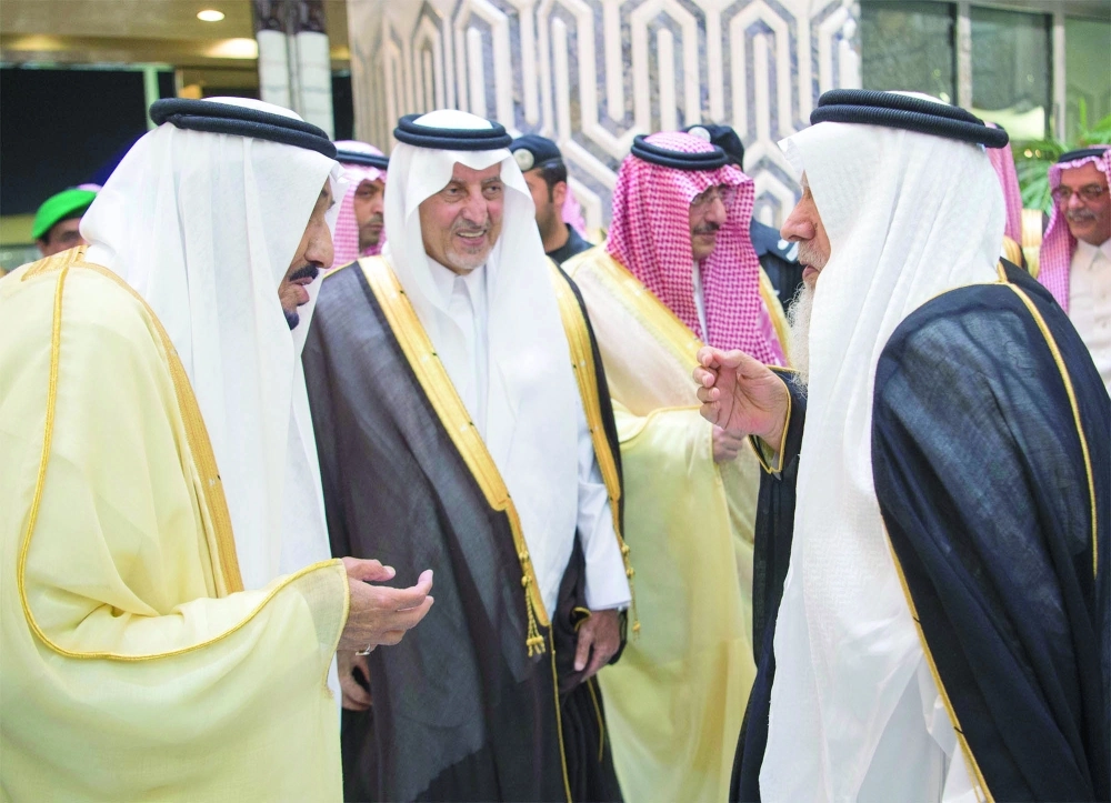 خادم الحرمين محييا مستقبليه وإلى جانبه أمير مكة