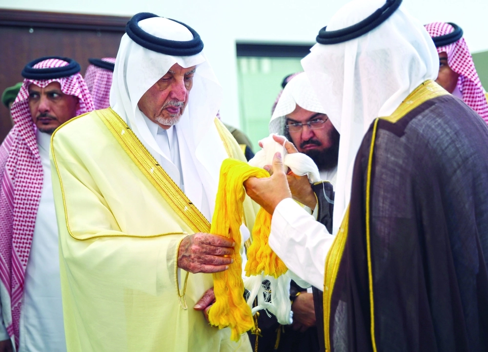  خالد الفيصل يلامس خيوط كسوة الكعبة خلال زيارته أمس               (ياسر بخش) 