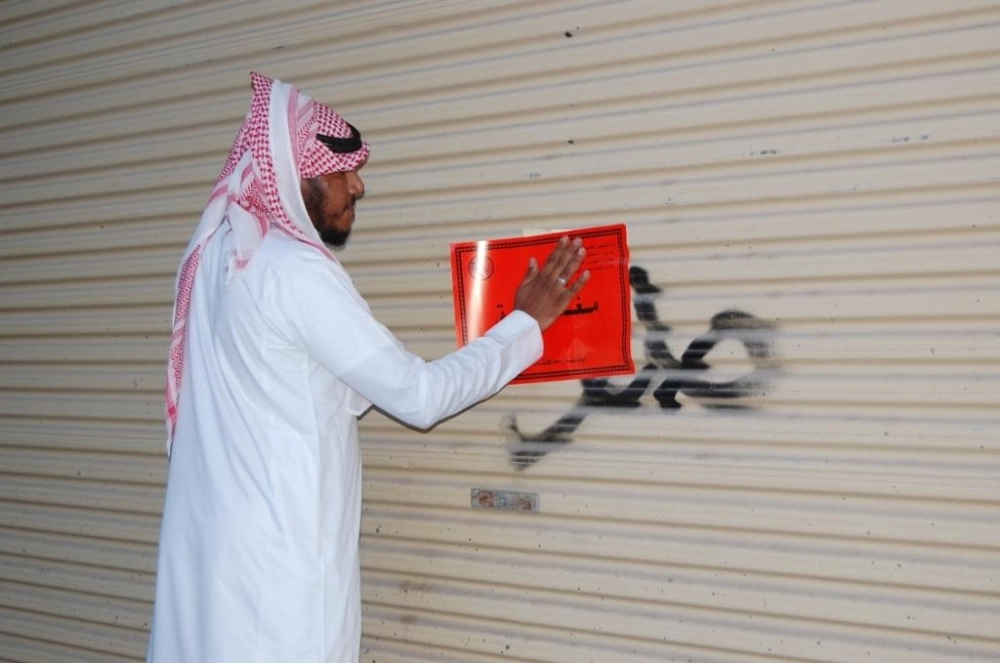 موظف البلدية خلال إغلاق أحد المطعمين   (مكة)