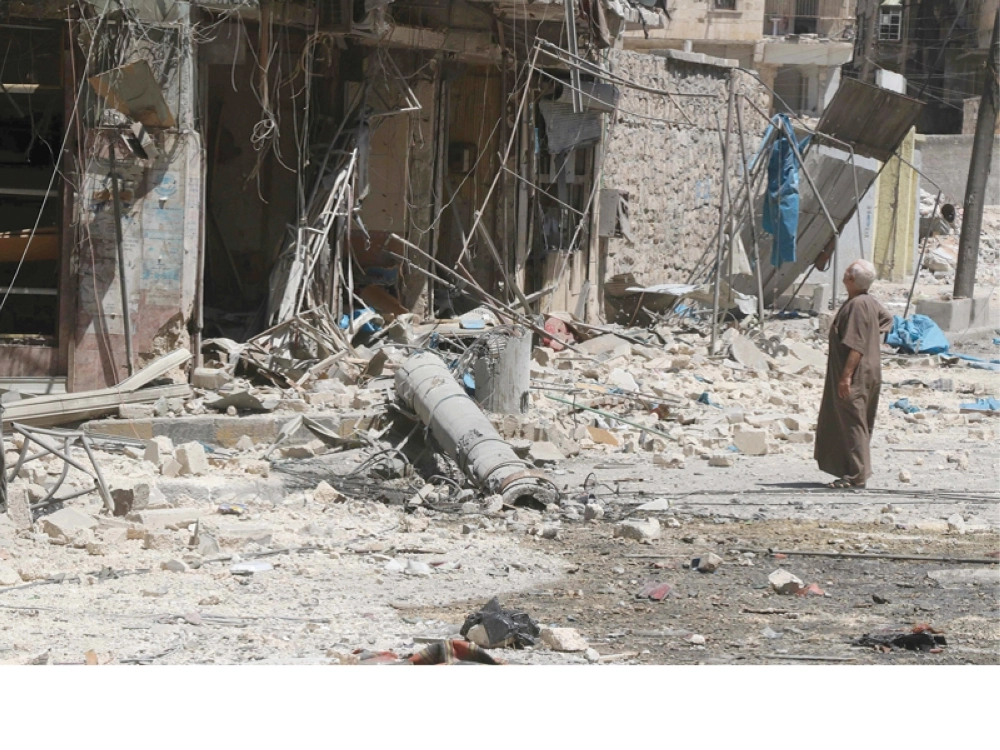 سوري يشاهد دمارا خلفته غارة للنظام في حلب أمس ( أ ف ب )