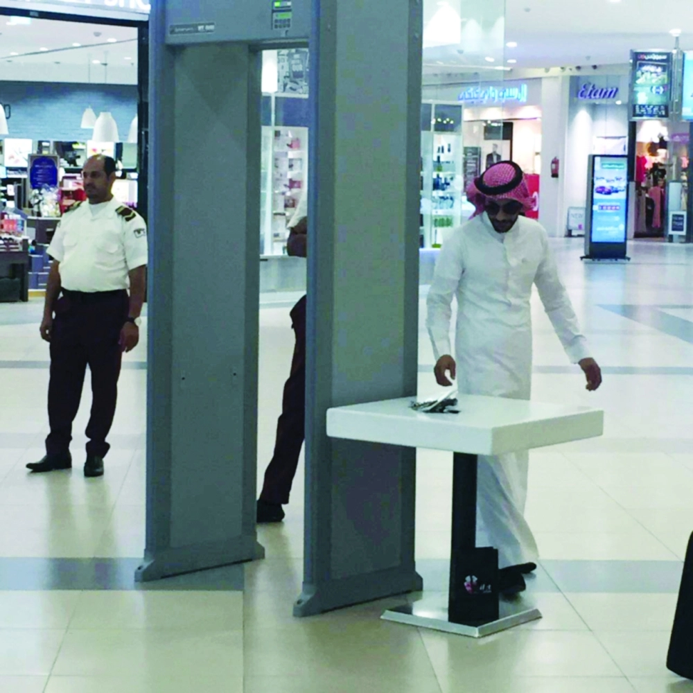 متسوق يستعد للمرور بالجهاز في أحد مولات المدينة    (مكة)