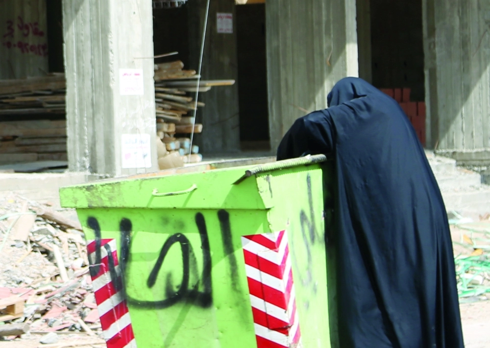امرأة تنبش حاوية نفايات           (مكة)