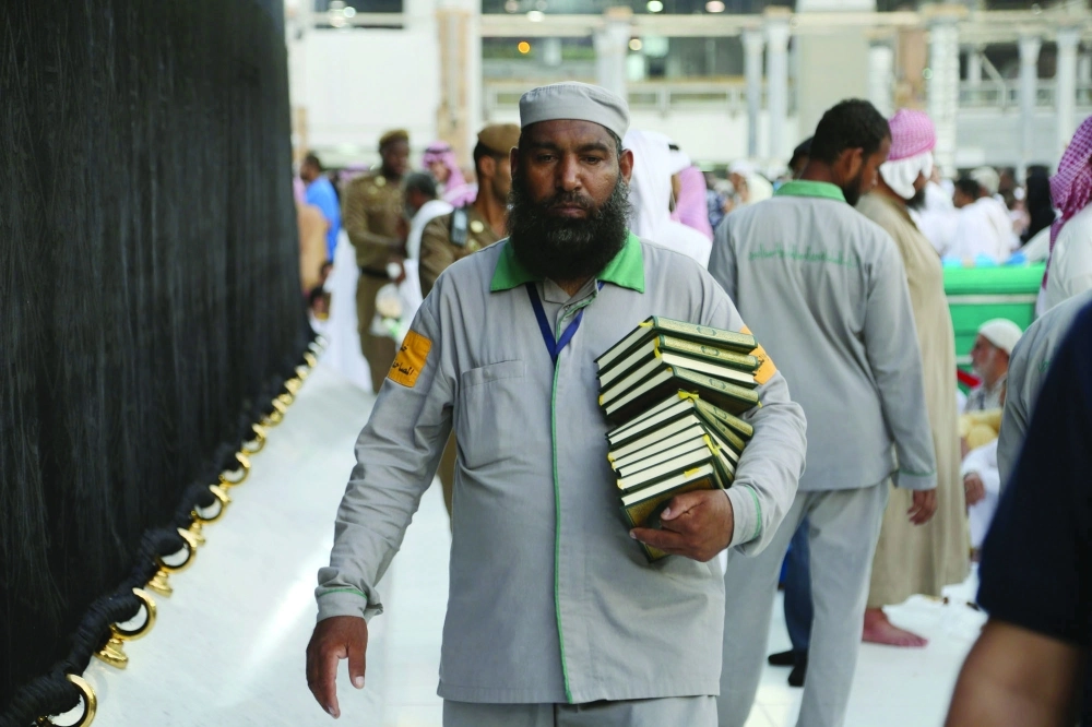 عامل يحمل مصاحف داخل المطاف        (مكة)