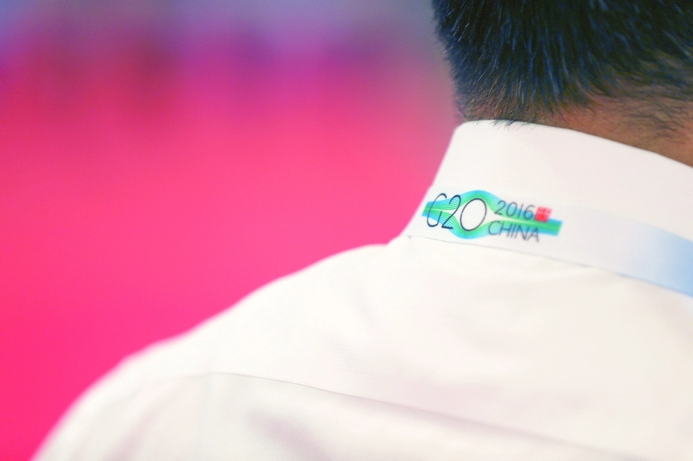 شعار العشرين على ملابس المنظمين