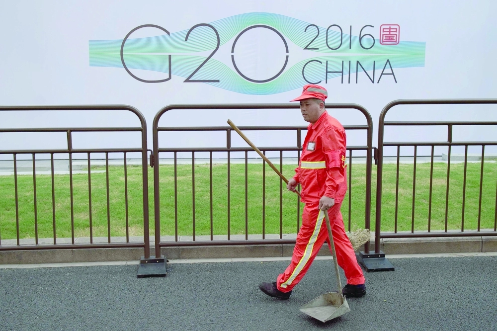 عامل نظافة بجانب المبنى الذي ستقام فيه القمة           