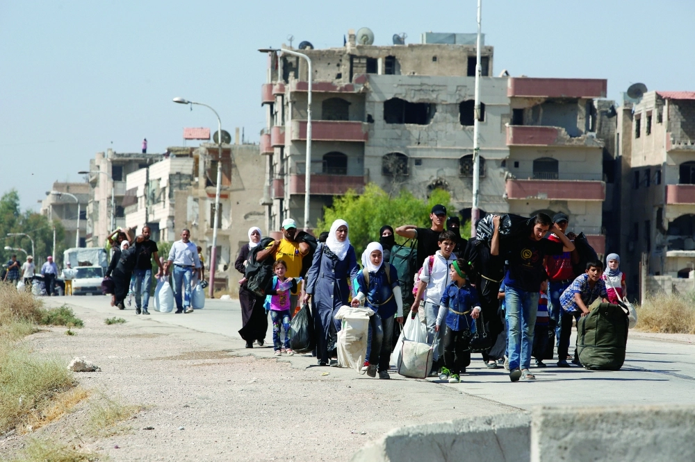 سوريون لدى نزوحهم من معضمية الشام أمس                                            (رويترز)