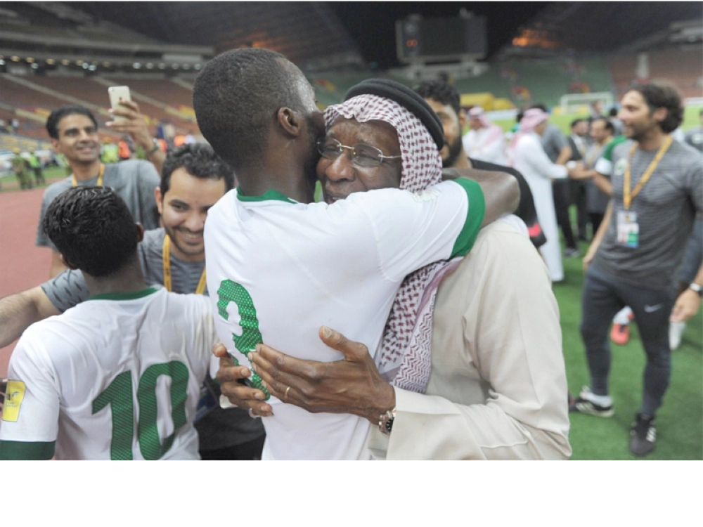 عناق بين أحمد عيد وأسامة هوساوي بعد الفوز على العراق أمس (واس)