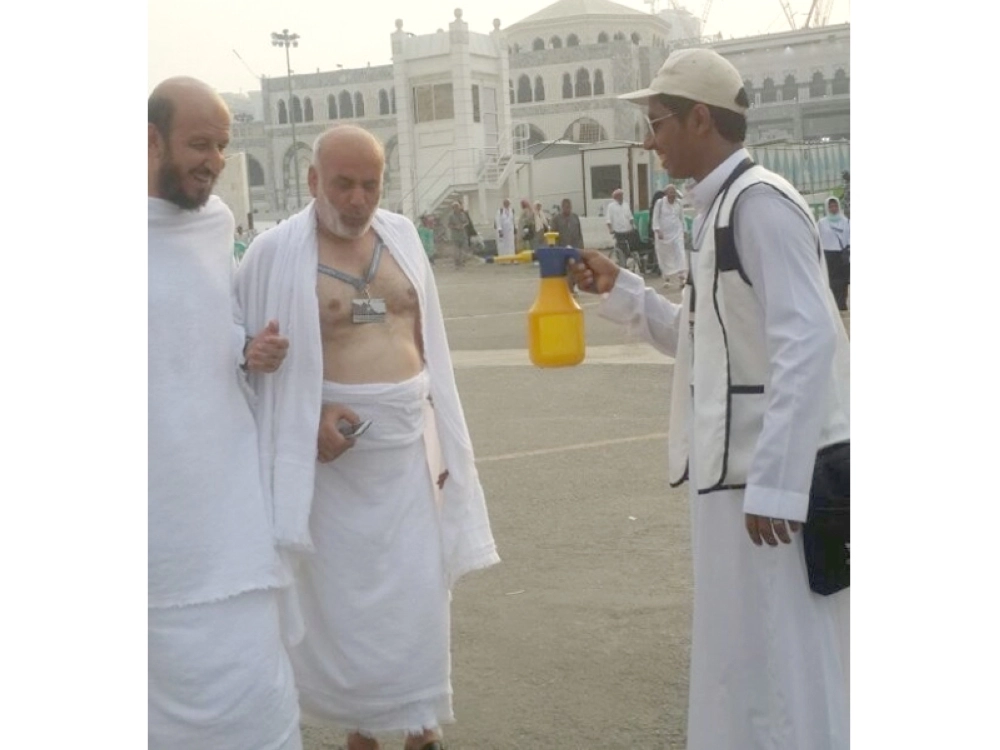 حاجان يبتسمان بعد رشهما بالماء (واس)