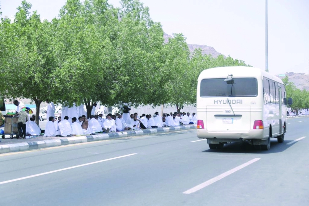 حجاج يستظلون على الرصيف الفاصل بين شارعين في منى                