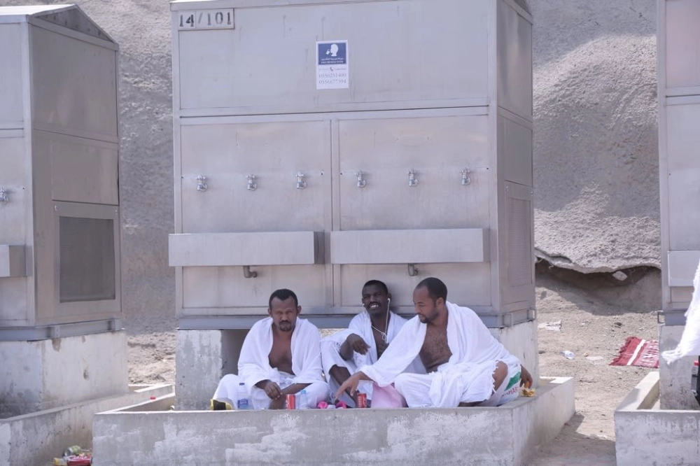 حجاج استقر بهم الحال للجلوس على أحد برادات المياه 
(أحمد جابر) 