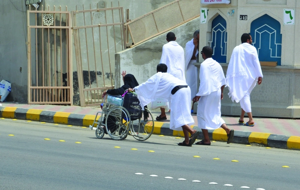 حاج يدفع عربة والدته المسنة لأداء الفريضة (عبدالمحسن دومان)