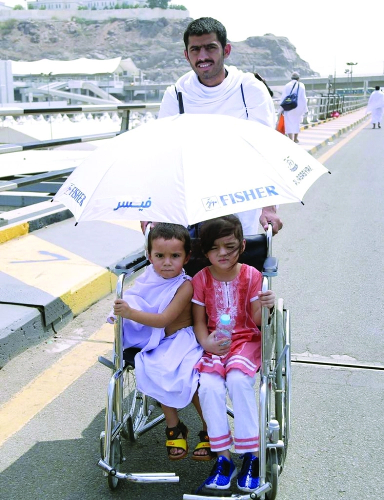 حاج يدفع عربة تحمل طفليه  (أحمد جابر)
