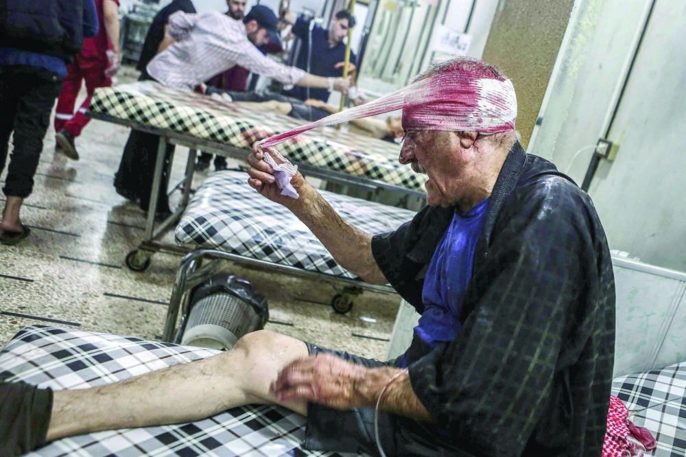 سوري يمسك ضمادة رأسه في مستشفى ميداني بدوما، عقب إصابته بغارة للنظام                (إ ب أ) 