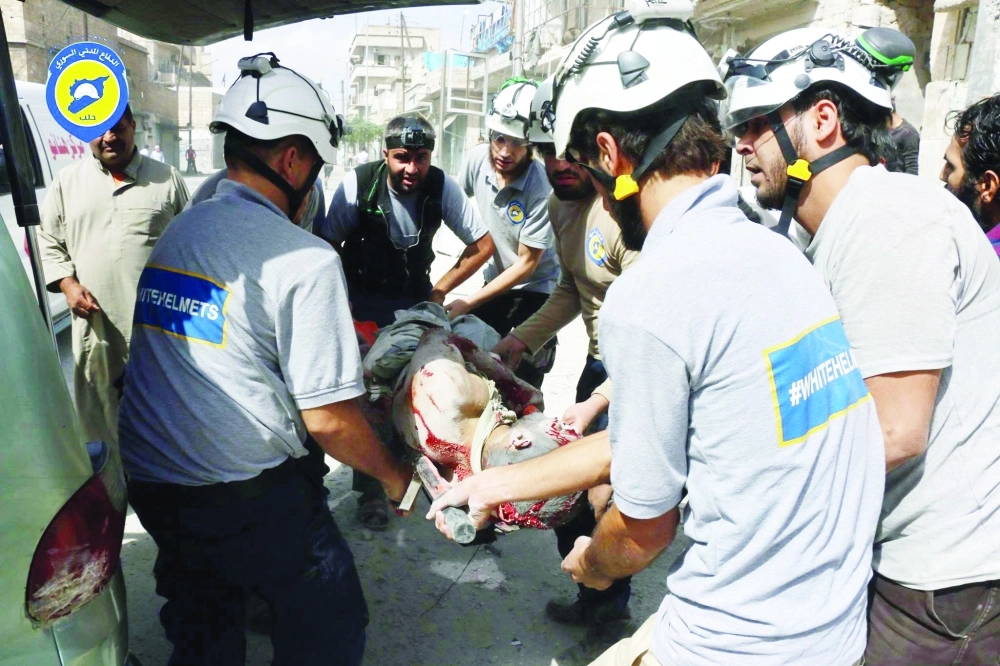 منقذون يحملون مصابا إثر قصف النظام وأعوانه شرق حلب               (أ ب) 