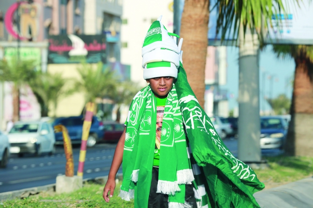 طفل يتوشح اللون الأخضر احتفاء باليوم الوطني (حمدان الدوسري)