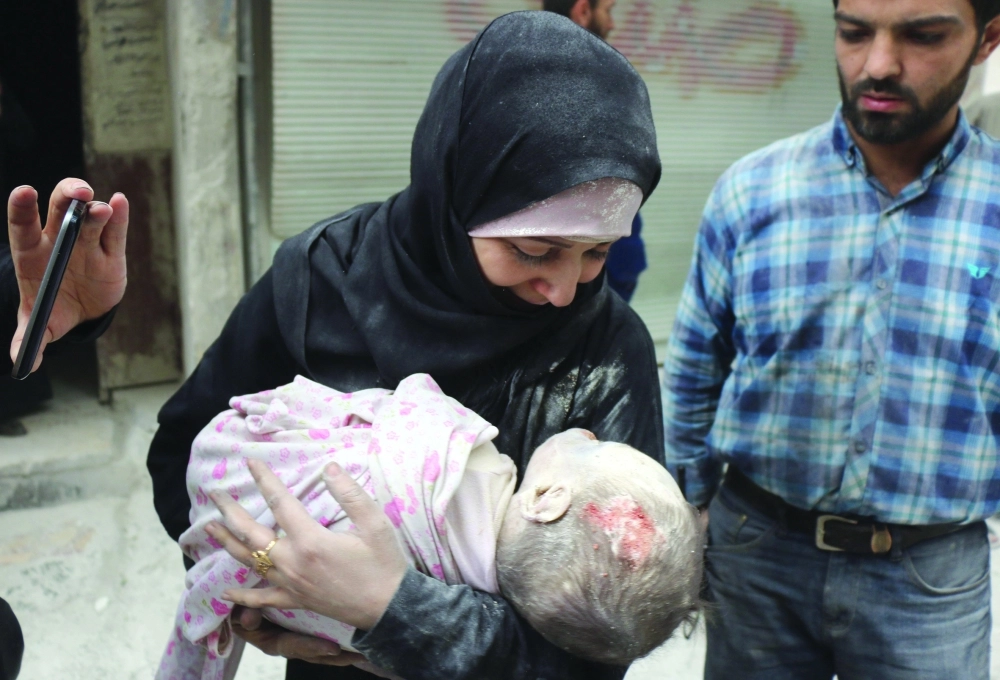 سورية تحمل جثة طفلها عقب غارات النظام وأعوانه على حلب                                                         (أ ف ب)