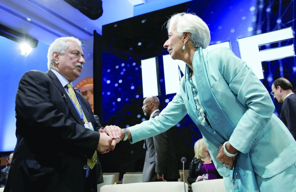 العساف مصافحا رئيسة صندوق النقد الدولي كريستيان لاجارد على هامش اجتماع الصندوق         (رويترز)