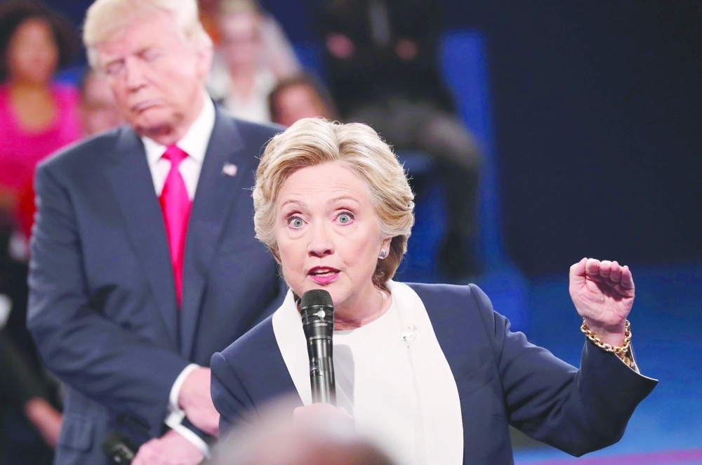 ترامب يستمع إلى كلينتون أثناء المناظرة في سانت لويس (أ ف ب)