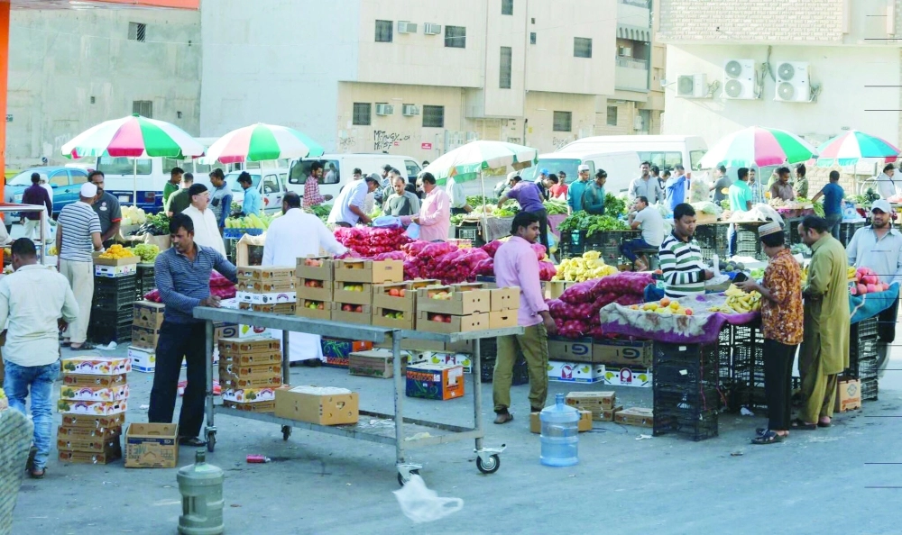 عمالة تفترش الشوارع وتبيع مواد غذائية بحي الوزارات في الرياض أمس                                                                         (محمد مشهور)